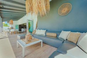 a living room with a blue couch and a table at Walk to Beach - Private Pool Villa in Palm-Eagle Beach
