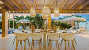 a dining room with a table and chairs in a house at Walk to Beach - Private Pool Villa in Palm-Eagle Beach