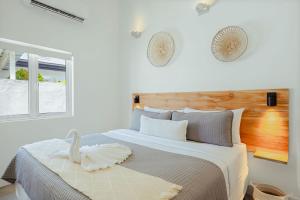 a white bedroom with a large bed and a window at Walk to Beach - Private Pool Villa in Palm-Eagle Beach +170 photos