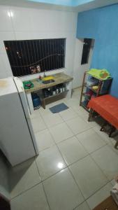 a kitchen with a refrigerator and a table in it at Casa Hostel da Cida in Pipa