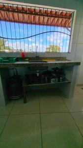 a kitchen counter with a sink and a window at Casa Hostel da Cida in Pipa