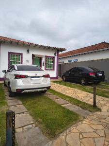 two cars parked in front of a house at Pouso Elohim in Tiradentes