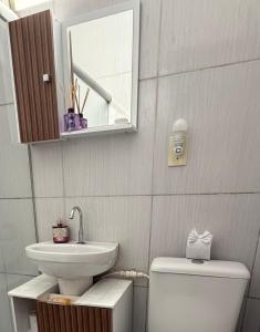 a bathroom with a sink and a toilet and a mirror at Sol e mar in Serra +13 photos