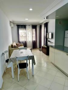 a kitchen and living room with a table and a couch at Appartement le jasmin in Hammamet