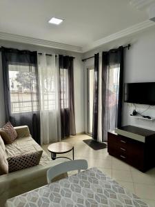 a living room with a bed and a couch and a tv at Appartement le jasmin in Hammamet