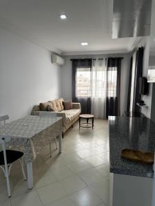 a living room with a couch and a table at Appartement le jasmin in Hammamet