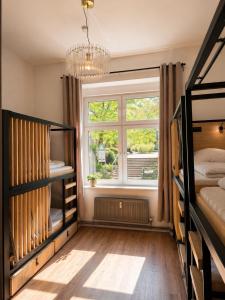 a bedroom with two bunk beds and a window at Berlin Sleep Club in Berlin