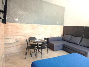 a living room with a couch and a table and chairs at Terrazza Cristallini Napoli in Naples