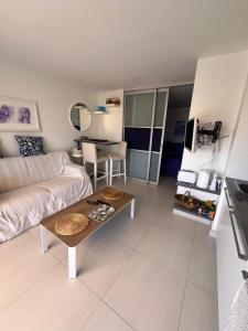 a living room with a couch and a table at TOUT A PIED Dernier étage Vue imprenable EST-SUD OUEST mer -plage 100m-box in Six-Fours-les-Plages