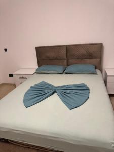 a bed with a blue bow tie on it at Apartmani Edi Ulcinj in Ulcinj