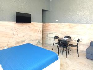 a bedroom with a blue bed and a table and chairs at Terrazza Cristallini Napoli in Naples