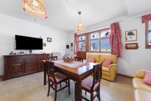 a living room with a dining room table and a tv at Tabià Padola in Padola