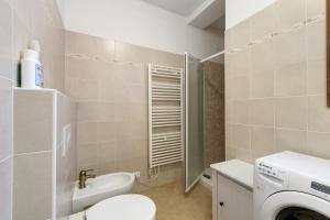 a bathroom with a toilet and a sink and a washing machine at Tabià Padola in Padola +19 photos