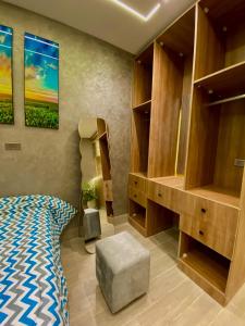 a bedroom with a bed and a desk and shelves at Nile residence in Al Kawāmil Qiblī
