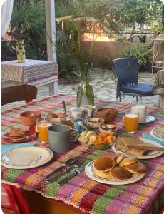 a breakfast table with pancakes and other food on it at Casa Roberta a due passi dal mare in Quartu Sant'Elena