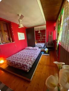 a bedroom with a bed with a red wall at Casa Roberta a due passi dal mare in Quartu Sant'Elena