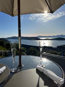 a table with two wine glasses on top of a balcony at Tigh Beag Pod with Hot Tub in Oban