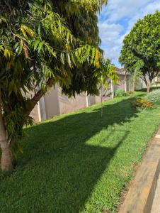a green lawn with trees in a yard at New Harambee Hotel in Nakwa
