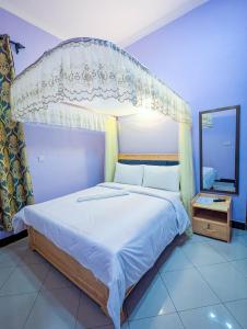 a bedroom with a large bed with a canopy at New Harambee Hotel in Nakwa