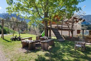 a playground with wooden benches and a tree at Petrunderhof in Villnoss