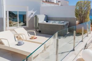 a patio with a hot tub and chairs on a balcony at Maryvilla Inspiración y Vacaciones - Villa Mascarat in Calpe +58 photos