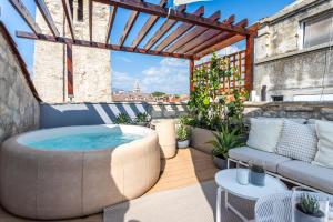 a hot tub on a patio with a couch at Apartment Luxury Palace No1 in Split