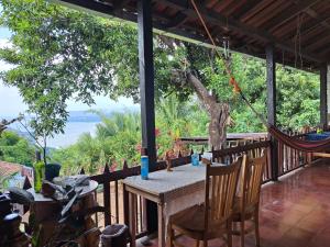 a table and chairs on a porch with a view of the ocean at CASA LICHIs in Suchitoto
