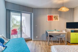 a room with a bed and a desk and a table at Le Murmure pieds dans l'eau in La Grande Motte