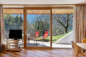 a living room with sliding glass doors and a tv at Petrunderhof in Villnoss