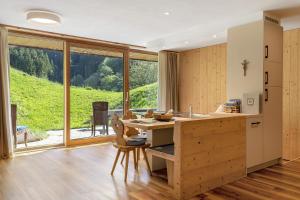 a kitchen with a table and a large window at Petrunderhof in Villnoss