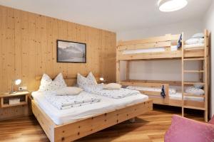 a bedroom with two beds and a bunk bed at Petrunderhof in Villnoss