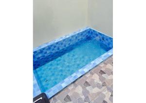 a swimming pool with blue tile in a bathroom at D'BAGOES Luxury Cabin in Sarangan