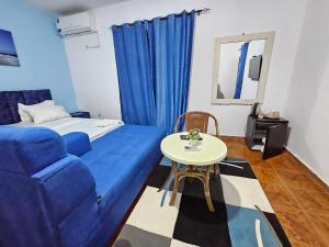 a room with a blue couch and a table at Vince Saly in Saly Portudal