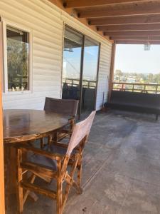 a wooden table and chairs on a patio with windows at Tinajas martina in Las Cruces
