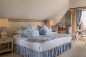 a bedroom with a bed with blue and white pillows at Manoir de Lan Kerellec - Relais & Châteaux - Etoilé Michelin in Trébeurden +69 photos