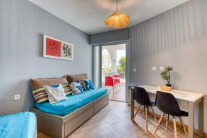 a room with a blue couch and a table and chairs at Le Murmure pieds dans l'eau in La Grande Motte