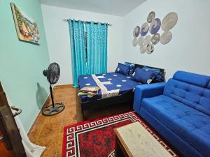 a living room with a blue couch and a bed at Vince Saly in Saly Portudal +4 photos
