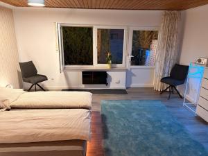 a bedroom with a bed and two chairs and a window at Nur ein paar Schritte zum Dümmersee in Hüde