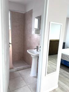 a white bathroom with a sink and a mirror at Puesta del Sol Apart in Río Gallegos +26 photos