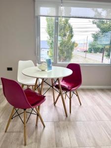a white table and two chairs and a table and a window at Puesta del Sol Apart in Río Gallegos