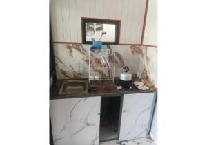 a kitchen with a counter and a sink at D'BAGOES Luxury Cabin in Sarangan