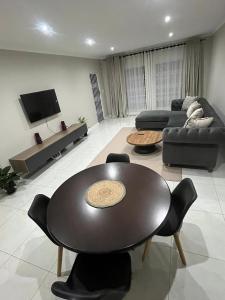a living room with a table and a couch at The Kempton Star in Kempton Park