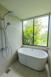 a white bath tub in a bathroom with a window at G.bouquet in Nakijin +75 photos