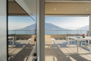 a balcony with tables and chairs and a view of the mountains at Valarin Residence & Villa Valarin Elite by Rent All Como in Vercana