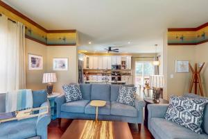 a living room with blue couches and a kitchen at Anchors Aweigh in Edgewater