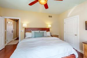 a bedroom with a large white bed with a ceiling fan at Anchors Aweigh in Edgewater