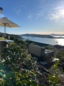 a bath tub sitting on the ground with an umbrella at Tigh Beag Pod with Hot Tub in Oban +13 photos