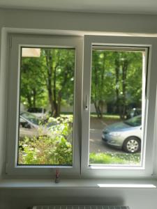 a window in a room with a view of a car at Appart' Cosy proche Mulhouse in Illzach