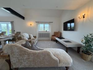 a living room with a couch and a table at Abbey Green Farm in Wem