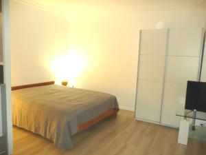 1 dormitorio con 1 cama y armario blanco en Tourelle, en Gagny